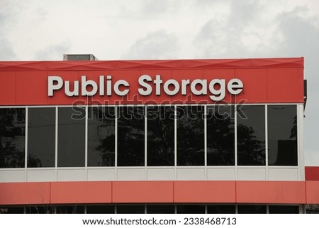 storage building public storage in white writing on orange background with dark windows, medium close shot
