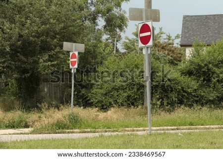 two do not enter road street signs, one in foreground and the other in background, red circle with white line in it on white background