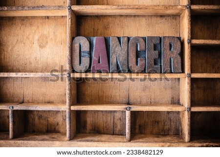 The word CANCER written in vintage wooden letterpress type in a wooden type drawer.