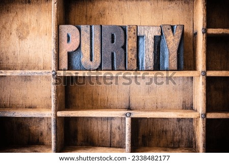 The word PURITY written in vintage wooden letterpress type in a wooden type drawer.