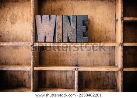 The word WINE written in vintage wooden letterpress type in a wooden type drawer.