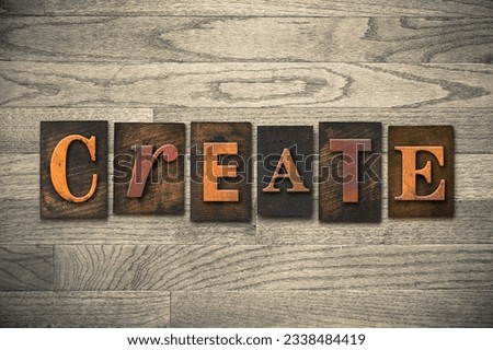 The word -CREATE- theme written in vintage, ink stained, wooden letterpress type on a wood grained background.