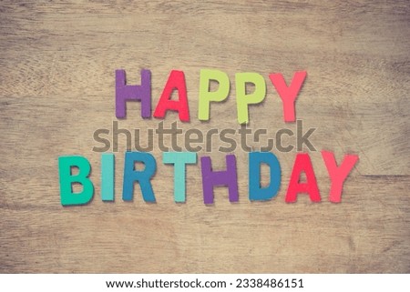 The colorful words -HAPPY BIRTHDAY- made with wooden letters on old wooden plank.