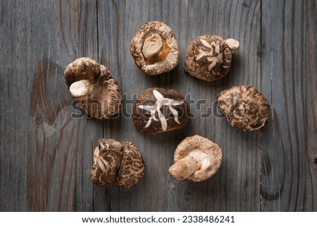Dried shiitake mushrooms on wooden background.