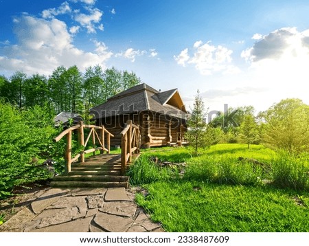 Wooden bridge and house of log in the forest