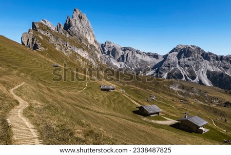 Landscape of Odle mountain peaks. Beatiful Seceda alpine pasture
with small mountain huts and a hiking trail. Famous tourist destination. Seceda, Val Gardena, italian Dolomites, Europe. Royalty-Free Stock Photo #2338487825