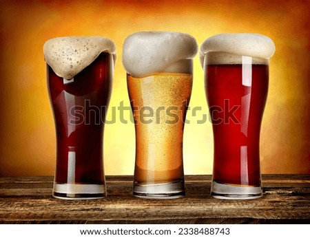 Three glasses of beer on a wooden table