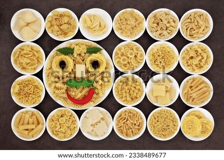 Abstract spaghetti and herb face with large pasta food selection in round bowls over brown background.