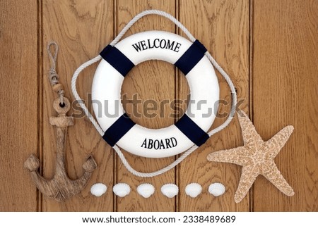 Decorative lifebuoy, wooden anchor, starfish and cockle shells over old oak background.