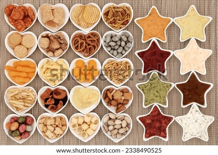 Crisp and dip party food selection in heart and star shaped porcelain bowls over bamboo background.