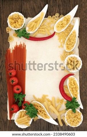 Italian pasta and mediterranean food ingredients forming an abstract border over old parchment and oak background.