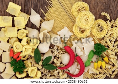 Pasta, herb and spice selection forming an abstract background over old oak wood.