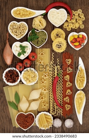 Italian pasta and mediterranean food ingredients forming an abstract background over oak.