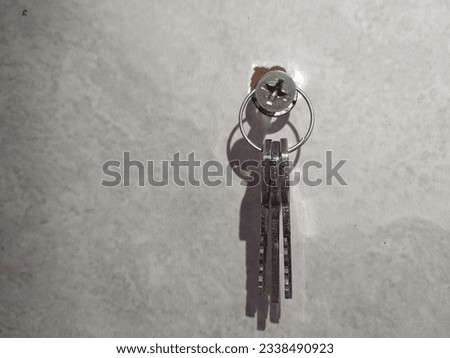 Keys, set of key is hanging on white color wall with wall screw, steel keys