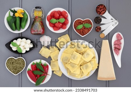 Italian and mediterranean food ingredients over grey wood background.