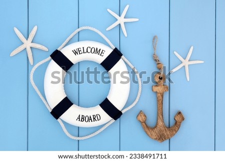 Decorative lifebuoy, anchor and starfish sea shells over wooden blue background.