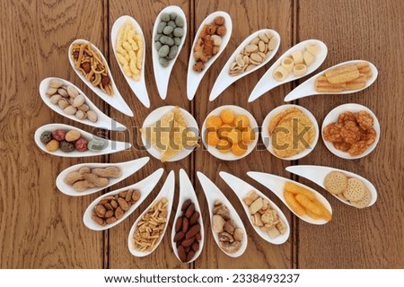 Savoury snack party food selection in porcelain dishes over oak background.