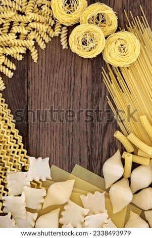 Abstract pasta food background border over old oak wood.