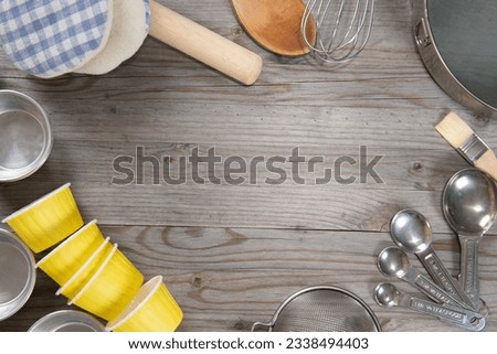 Various baking tools arrange from overhead view on wooden table in vintage tone. Copy space on middle.