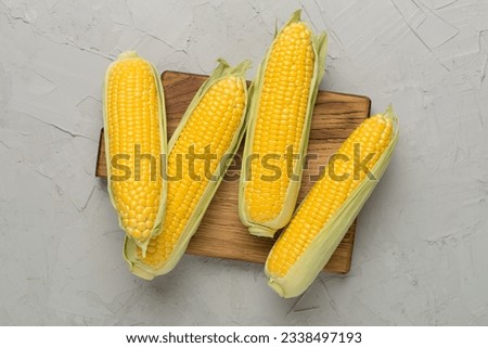 Fresh corn on cobs on concrete background, top view Royalty-Free Stock Photo #2338497193