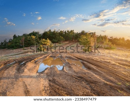 Puddle on a country road to mountain forest
