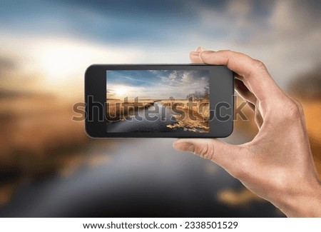Phone in hand on a background of nature