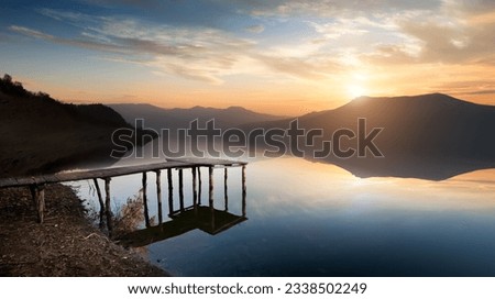 Fishing jetty on mountain river at sunset