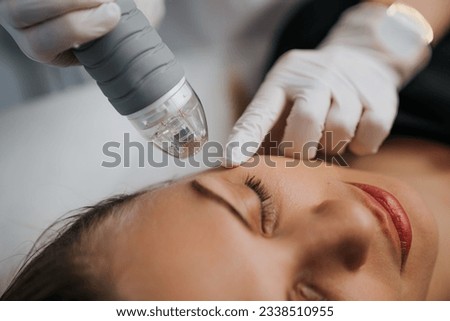 Microneedle RF lifting in a beauty salon. Big plan. High quality photo Royalty-Free Stock Photo #2338510955