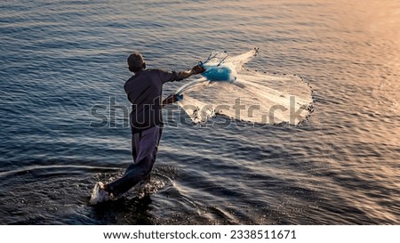 A fishermen throwing fishing net during sunrise in Al Khobar seaside Saudi Arabia. Royalty-Free Stock Photo #2338511671