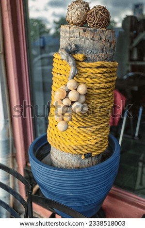 Yellow Nautical Rope and Floats in a Blue Vase.