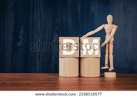 There is wood cube with the word DM. It is an abbreviation for Direct message as eye-catching image. Royalty-Free Stock Photo #2338518577