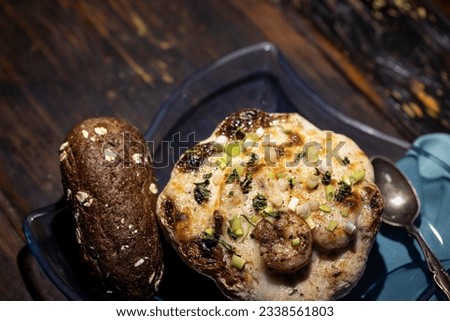 Au gratin served in a patty pan squash with bread. Royalty-Free Stock Photo #2338561803