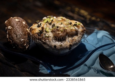 Au gratin served in a patty pan squash with bread. Royalty-Free Stock Photo #2338561865