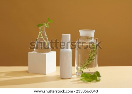 A conical flask, petri dish and a jar of centella leaves and seaweed arranged on brown background. Empty label bottle for cosmetic advertising of seaweed extract Royalty-Free Stock Photo #2338566043