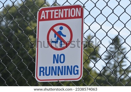 Attention No Running Sign on Chain Link Fence