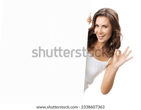 Happy smiling beautiful young woman showing blank signboard or copyspace for slogan or text, isolated over white background