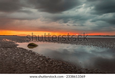 Moody dramatic skies and sunset reflections over Bowness on Solway Cumbria north east England UK Royalty-Free Stock Photo #2338613369