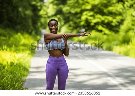 Active and fit young woman stretching her arms while exercising outdoors. Determined african american athlete doing a warmup for body to prepare for refreshing cardio workout or run and prevent injury