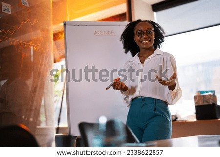 Businesswoman present her idea to working team. African businesswoman in conference room.	 Royalty-Free Stock Photo #2338622857