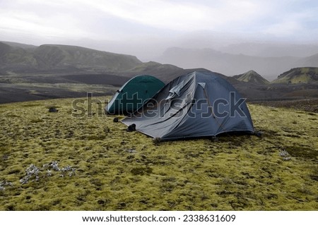 A tent flapping in strong wind. Landmannalaugar, Iceland, Europe. Windy day.  Royalty-Free Stock Photo #2338631609