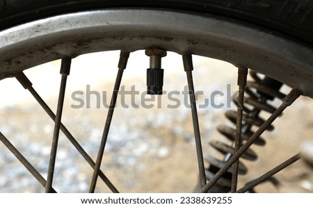 Close-up a Motorcycle tire valve,The air filler hole on the motorcycle wheel when the position is open,Tire Valve Stem with cap. black cap valve