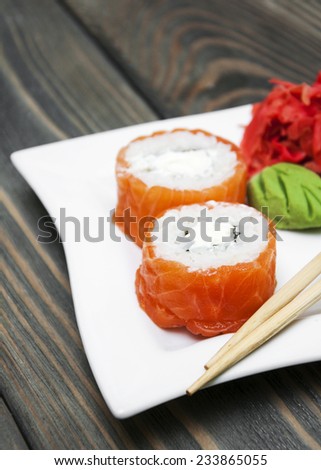Plate with rolls, wasabi and ginger on a wooden background