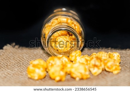 Close up picture popcorn spread on the sack with black color of background.concept picture of food style art.