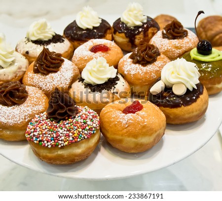 Fresh donuts on white plate in the bakery for Hanukkah celebration.