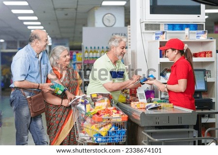 indian man doing payment with card after shopping at supermarket. digital payment concept. Royalty-Free Stock Photo #2338674101