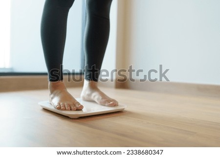 Lose weight. Fat diet and scale feet standing on electronic scales for weight control. Measurement instrument in kilogram for diet Royalty-Free Stock Photo #2338680347