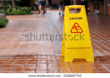 wet floor sign with water drops on wet stone floor. plastic sign warning.