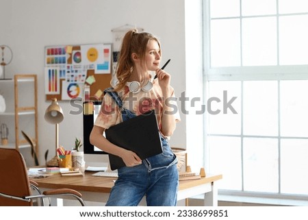 Female graphic designer working with tablet in office Royalty-Free Stock Photo #2338699851