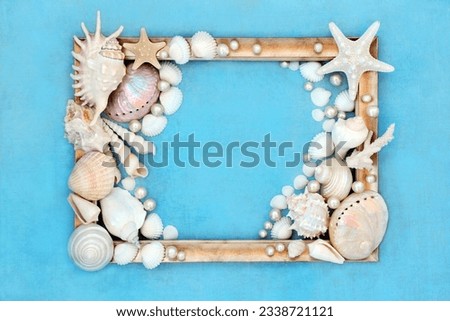 Sea shell and pearl abstract gold picture frame design on mottled blue background. Natural nature design with large collection of shells.