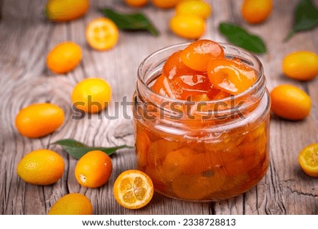 Homemade kumquat jam in jar and fresh kumquats, top view Royalty-Free Stock Photo #2338728813